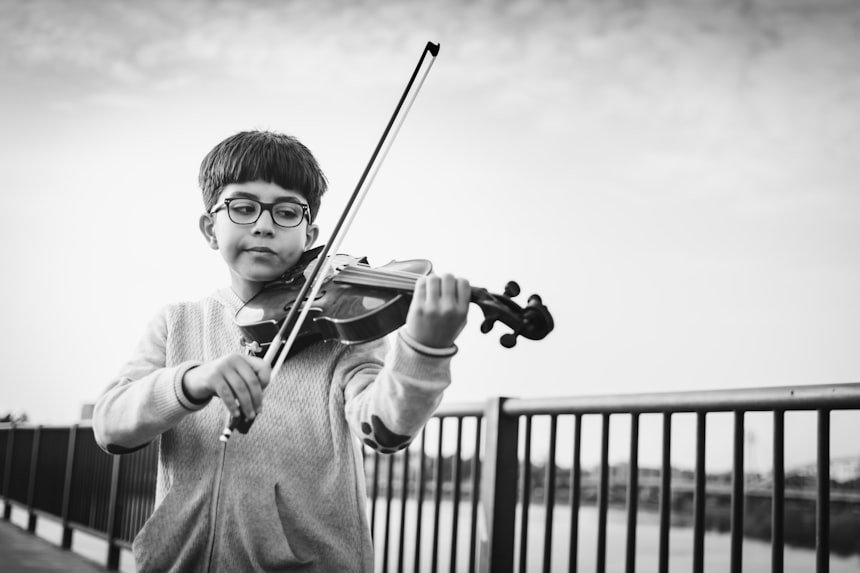 Boy playing violin — focused young student with bow on strings